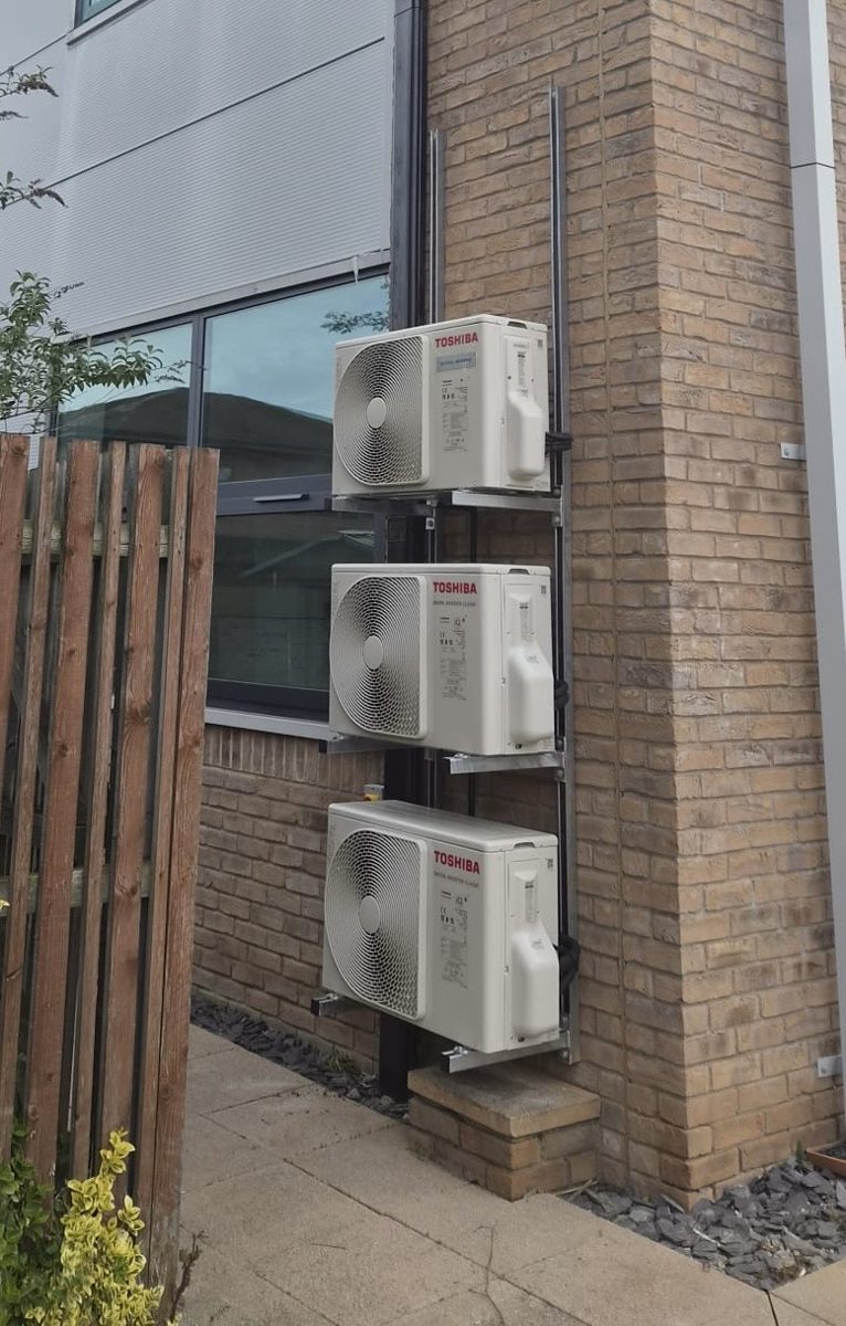Three Toshiba air conditioning condenser units neatly stacked on a commercial wall by RJM Refrigeration
